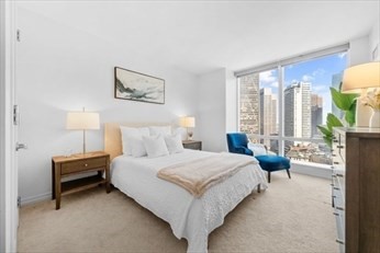 1 Franklin Street, Unit 2406 Boston, MA 02110 - Photo 5 of 22 a bedroom with a bed painting on wall and a large window