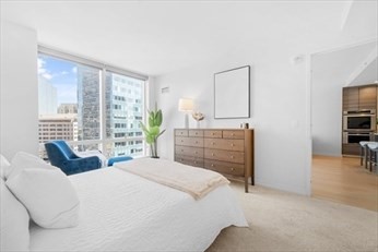 1 Franklin Street, Unit 2406 Boston, MA 02110 - Photo 6 of 22 a bedroom with a bed and a cabinets