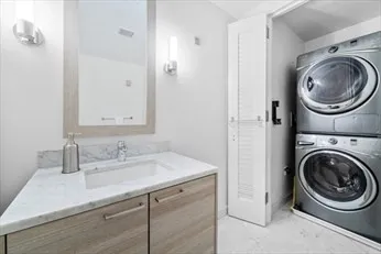 a bathroom with a sink a mirror and a washer dryer