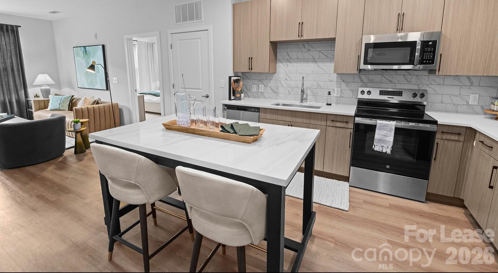 2546 Perimeter Pointe Parkway, Unit 1G Charlotte, NC 28208 - Photo 32 of 48 a kitchen with stainless steel appliances stove microwave and cabinets