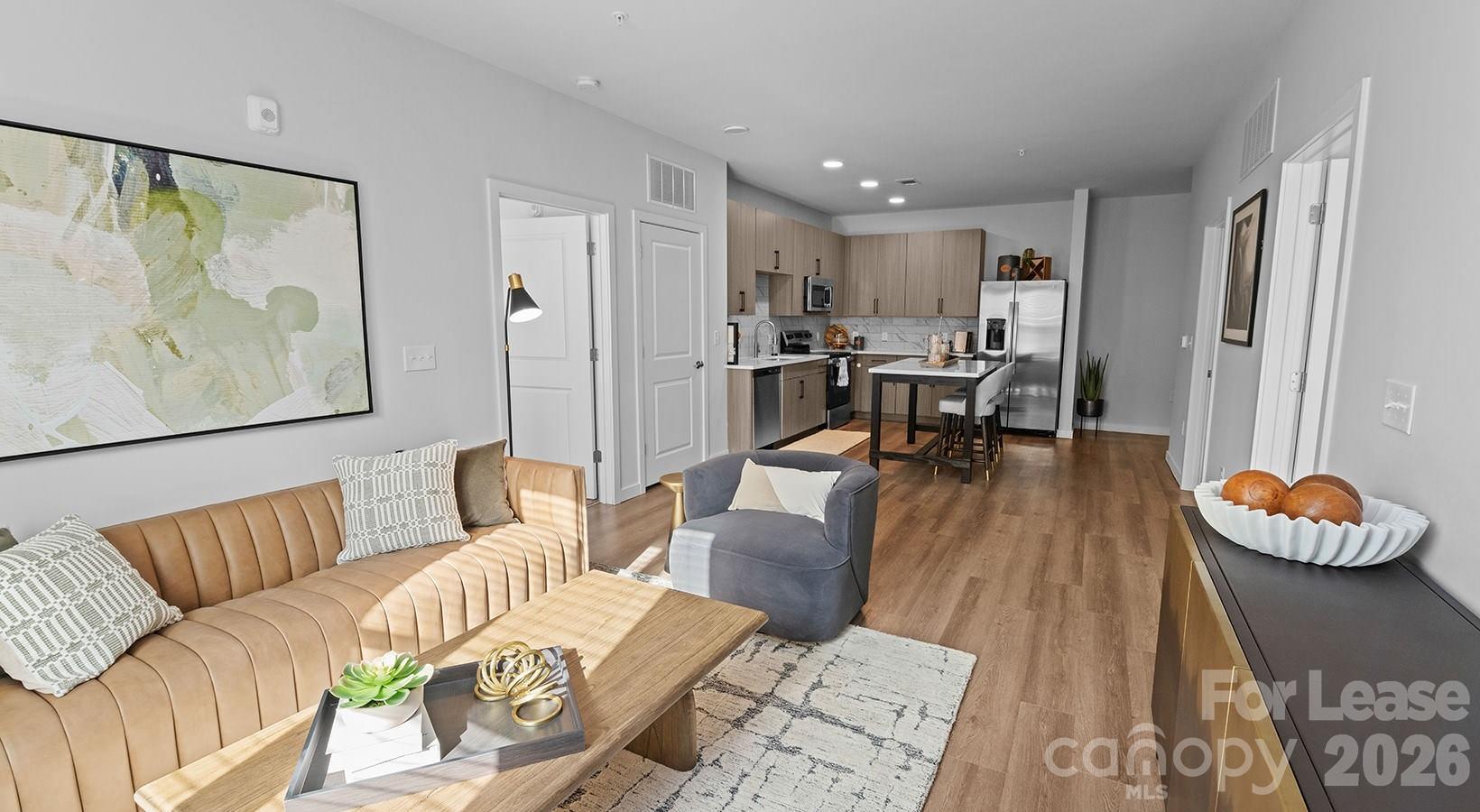 2546 Perimeter Pointe Parkway, Unit 1G Charlotte, NC 28208 - Photo 38 of 48 a living room with furniture and a dining table with wooden floor