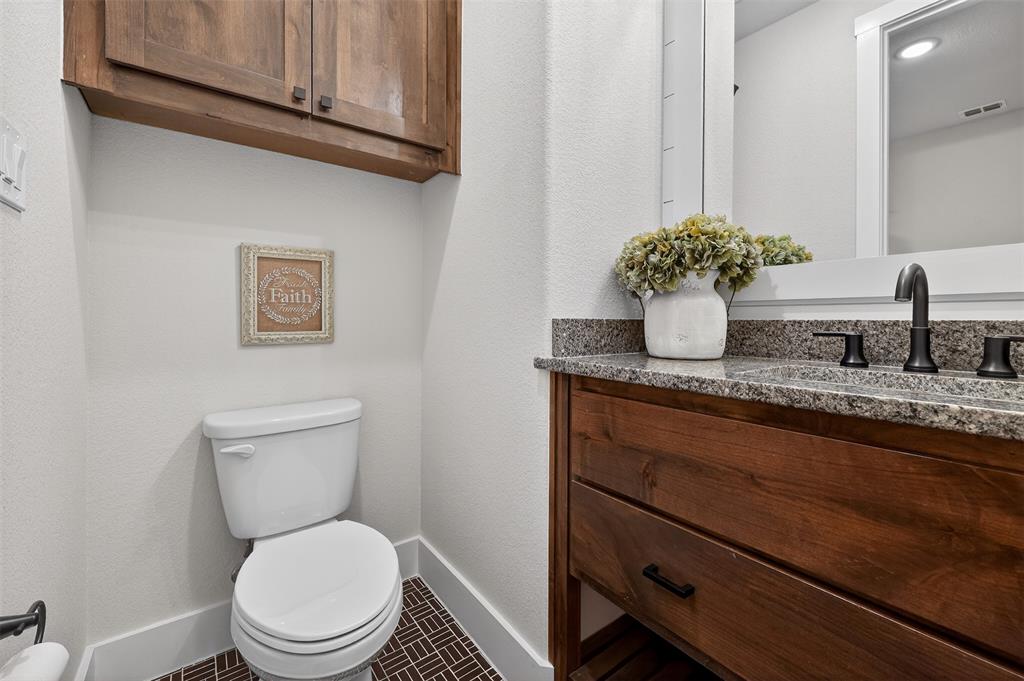 221 Proctor Lane Decatur, TX 76234 - Photo 24 of 30 a bathroom with a granite countertop toilet sink and mirror