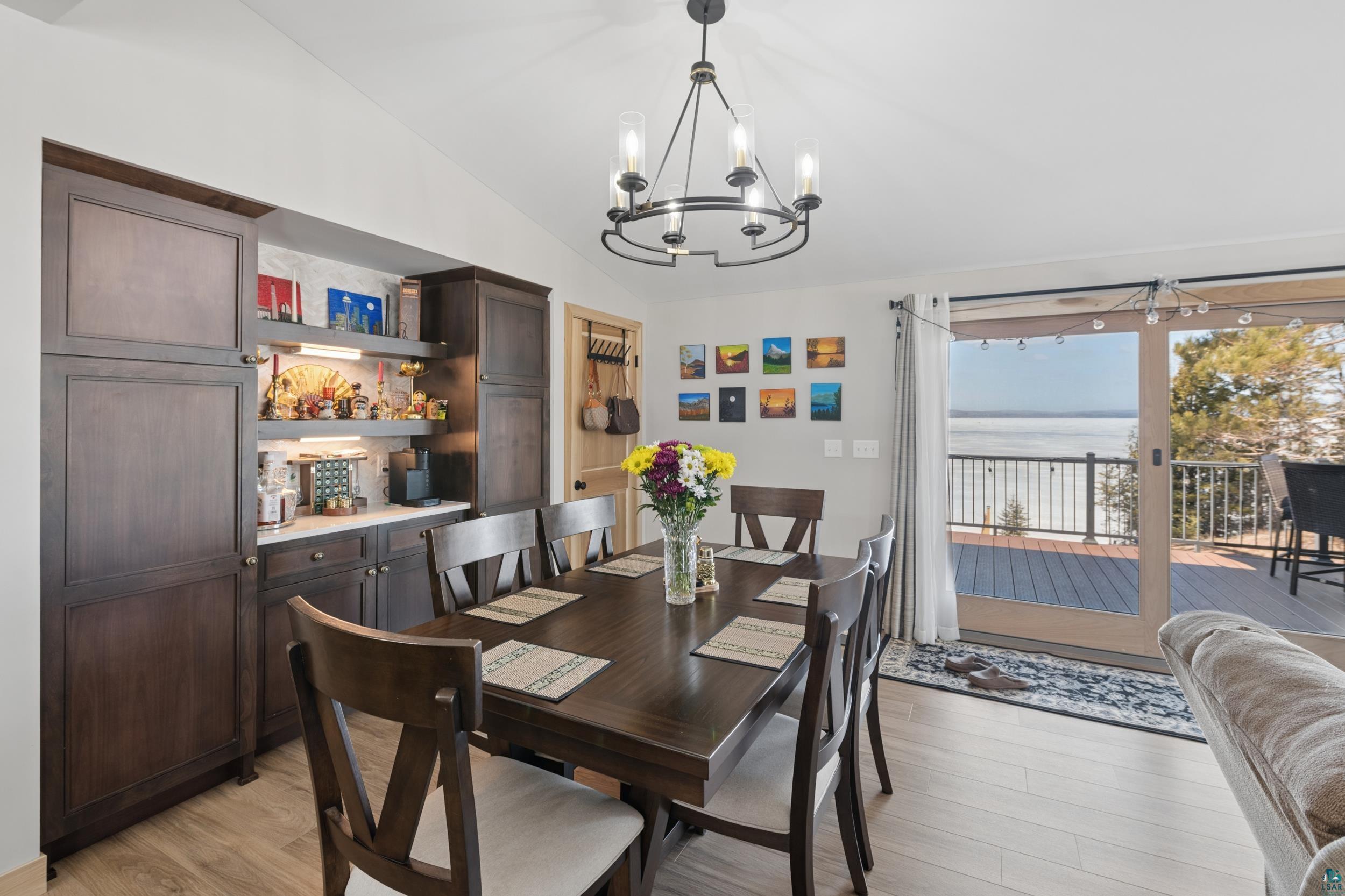 3903 Lake Park Road Ashland, WI 54806 - Photo 17 of 37 Dining room featuring vaulted ceiling, light wood-type flooring, hanging lights, and a water view