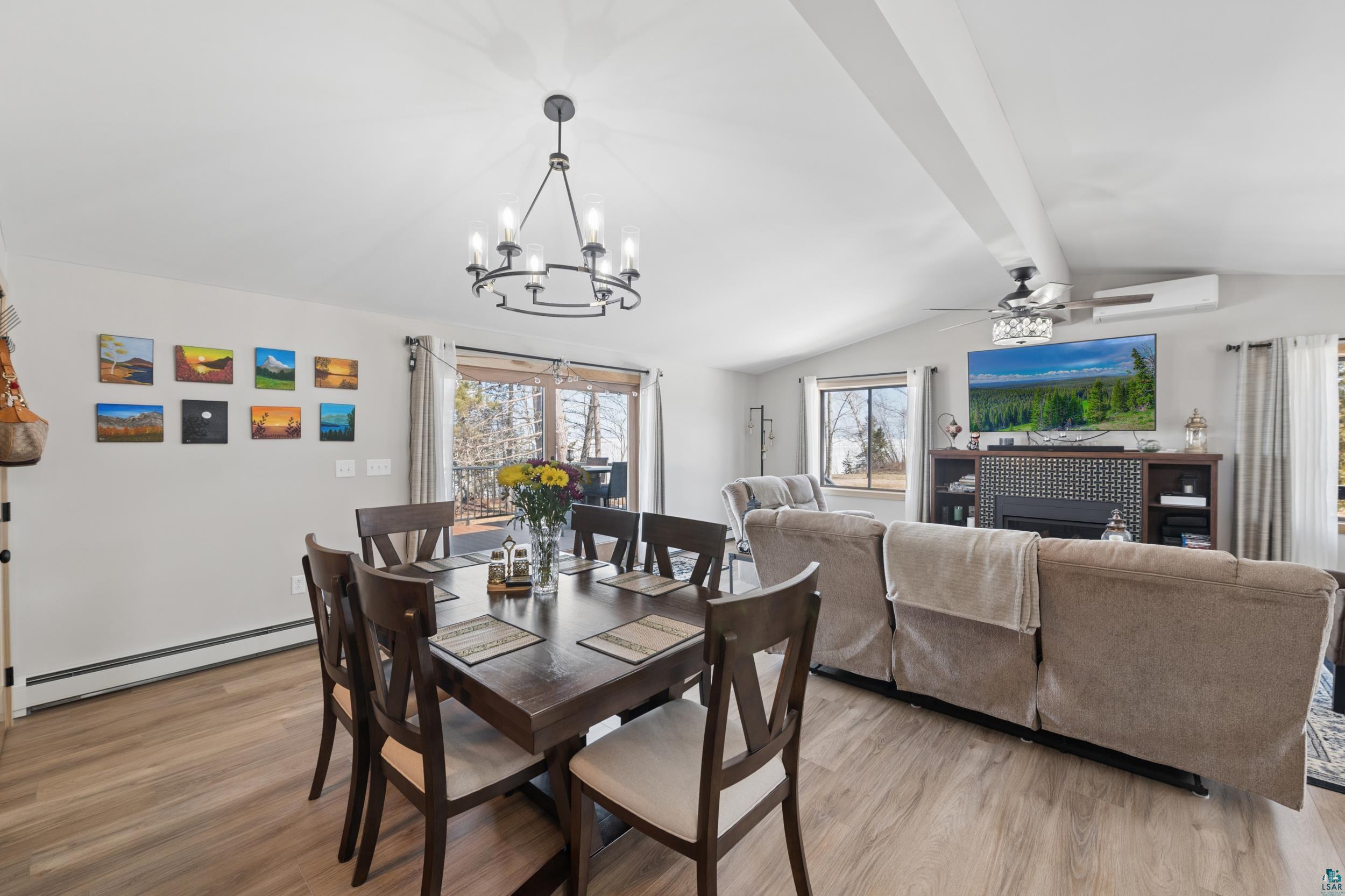 3903 Lake Park Road Ashland, WI 54806 - Photo 18 of 37 Dining space with light wood-type flooring, a baseboard radiator, a ceiling fan, beamed ceiling, and a chandelier