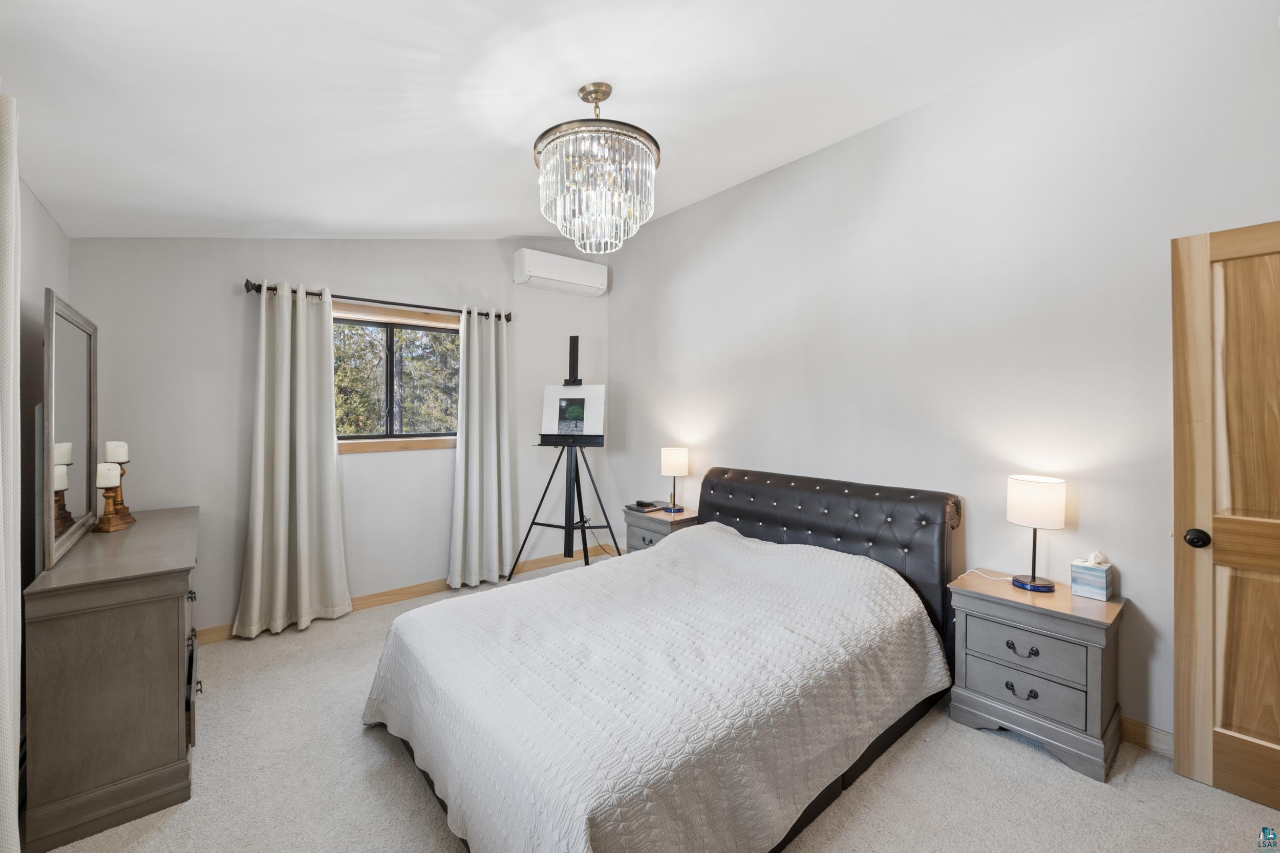 3903 Lake Park Road Ashland, WI 54806 - Photo 24 of 37 Carpeted bedroom featuring vaulted ceiling, suspended lighting, and a wall mounted mini split