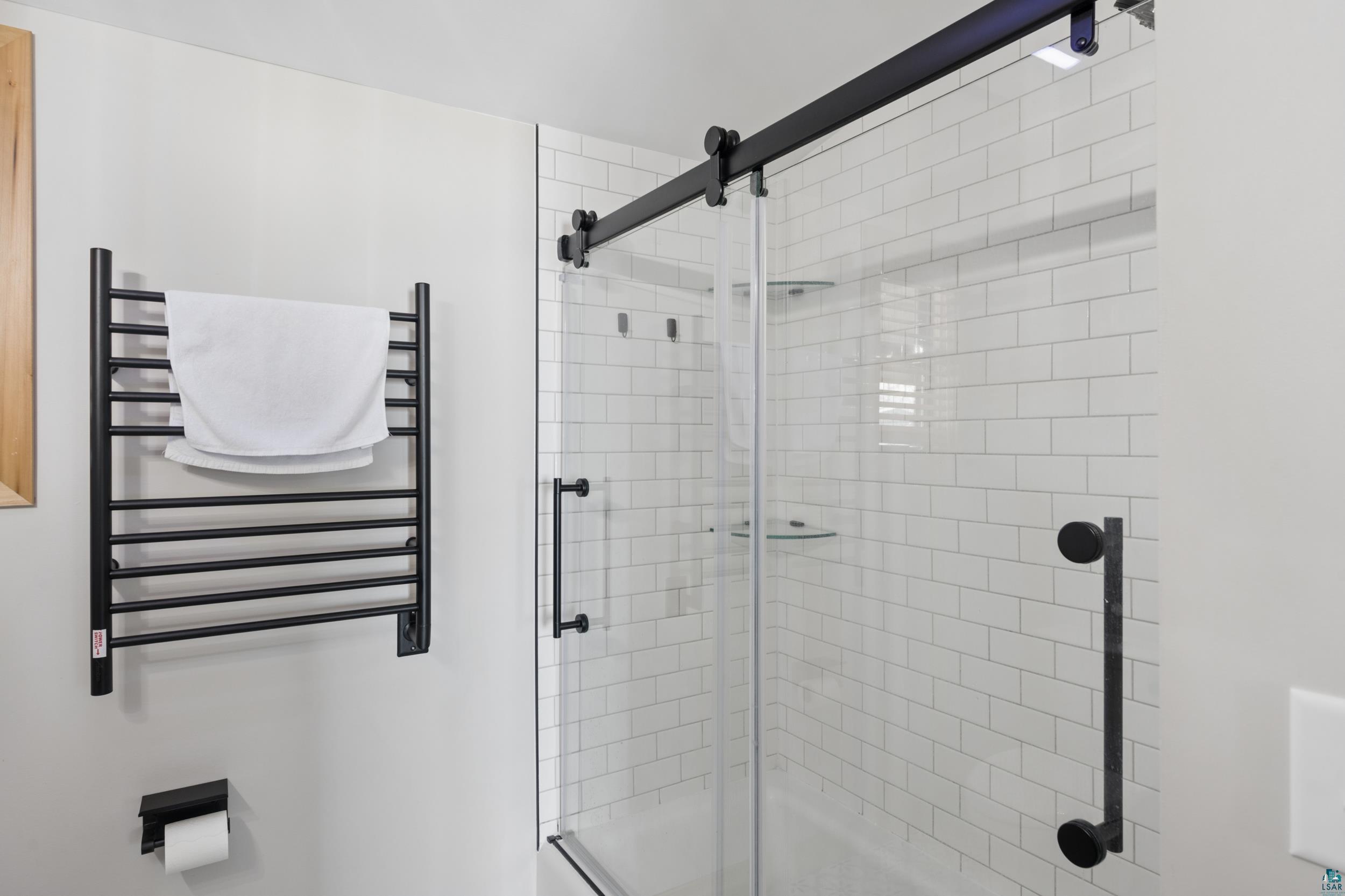 3903 Lake Park Road Ashland, WI 54806 - Photo 26 of 37 Bathroom with a towel warmer, radiator, and a tile shower