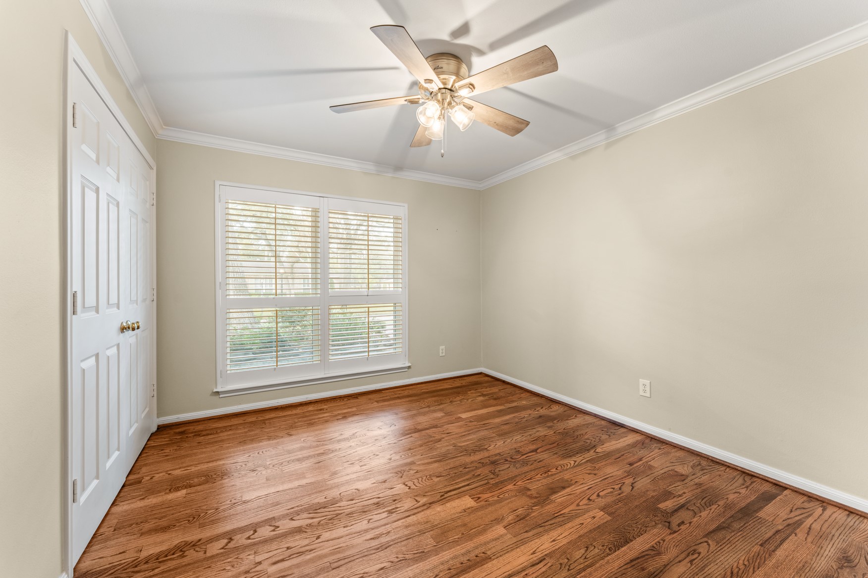 10203 Green Tree Road Houston, TX 77042 - Photo 17 of 28 Guest bedroom features hardwood floors, Plantation shutters, and ceiling fan.