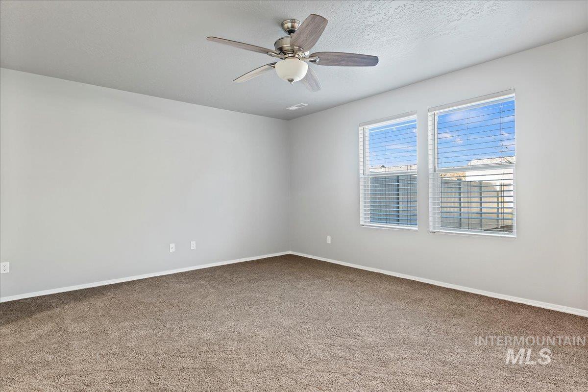916 West Woodpine Street Meridian, ID 83646 - Photo 12 of 32 Carpeted spare room with ceiling fan and a textured ceiling