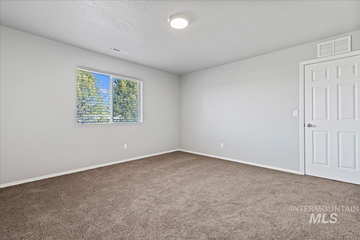 916 West Woodpine Street Meridian, ID 83646 - Photo 17 of 32 Carpeted spare room featuring a textured ceiling and baseboards