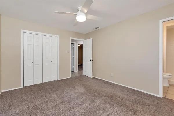 a view of an empty room and a ceiling fan window
