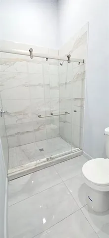 a bathroom with a toilet and a shower