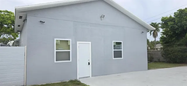 a view of a house with backyard and trees