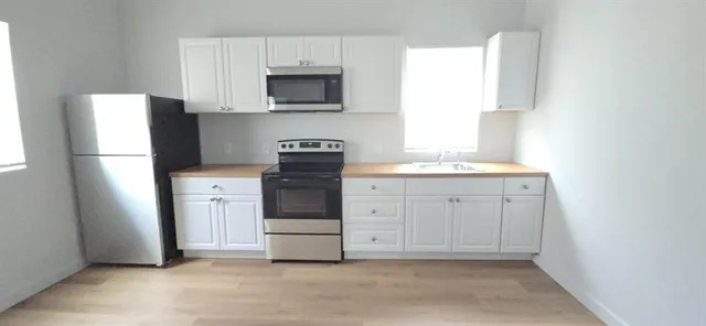 a kitchen with a sink a refrigerator and a microwave
