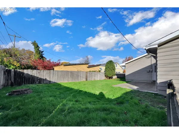 a view of a backyard with wooden fence