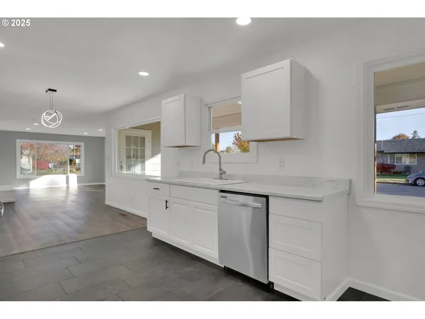 a kitchen with granite countertop white cabinets and a sink