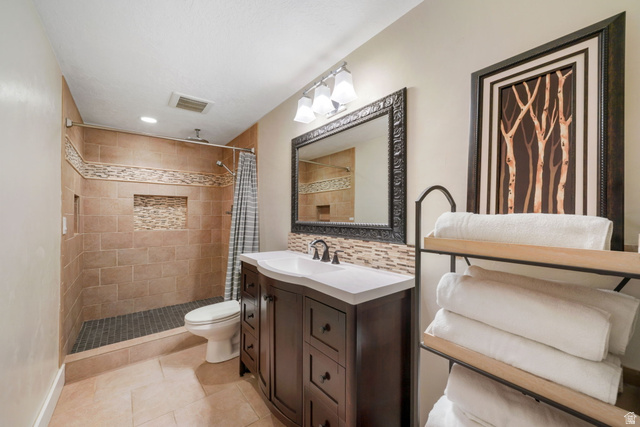 357 South 320 W Street Lindon, UT 84042 - Photo 27 of 41 Bathroom featuring a walk-in shower with stone tile walls, a mosaic accent band, and integrated niches