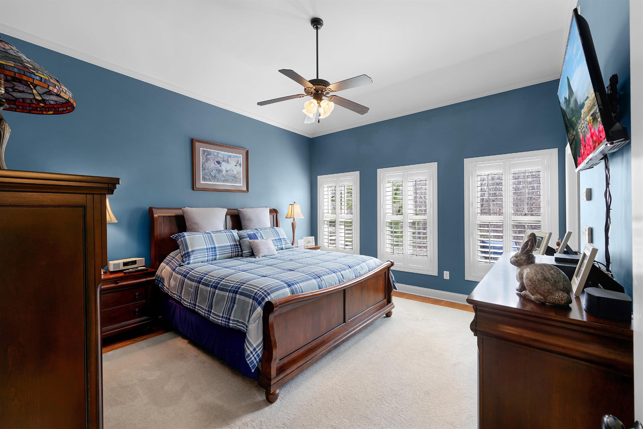 145 Deer Path Savannah, TN 38372 - Photo 13 of 23 a bedroom with a bed a chandelier and a flat tv screen