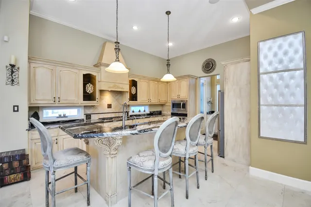 a kitchen with stainless steel appliances granite countertop a stove a sink a dining table and chairs with wooden floor