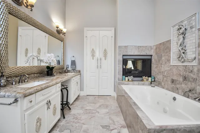a spacious bathroom with a granite countertop sink a toilet a mirror and bathtub