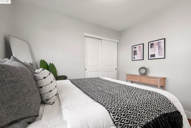 a bedroom with a bed and painting on the wall