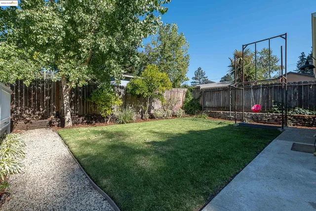 a backyard of a house with barbeque oven table and chairs