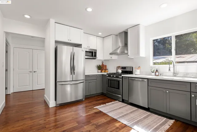 a kitchen with a refrigerator stove and wooden floor