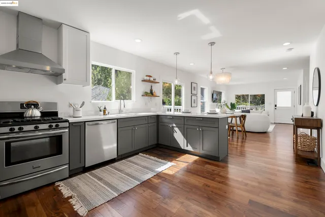 a kitchen with stainless steel appliances kitchen island granite countertop a sink cabinets and wooden floor