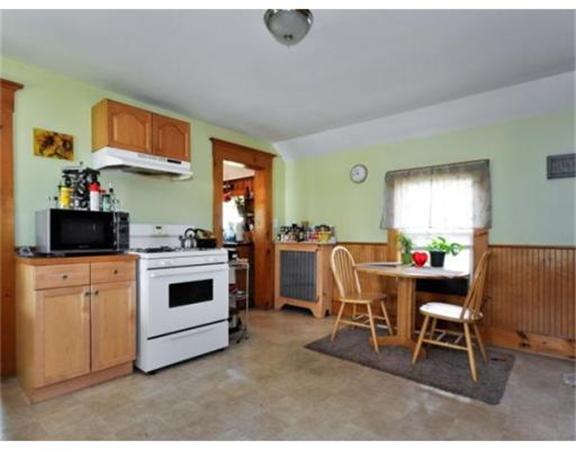 270 Spring Street Boston, MA 02132 - Photo 9 of 18 a kitchen with a stove a table and chairs in it