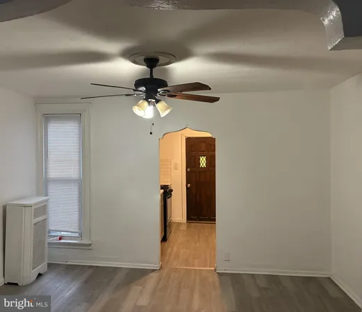an empty room with wooden floor closet and windows