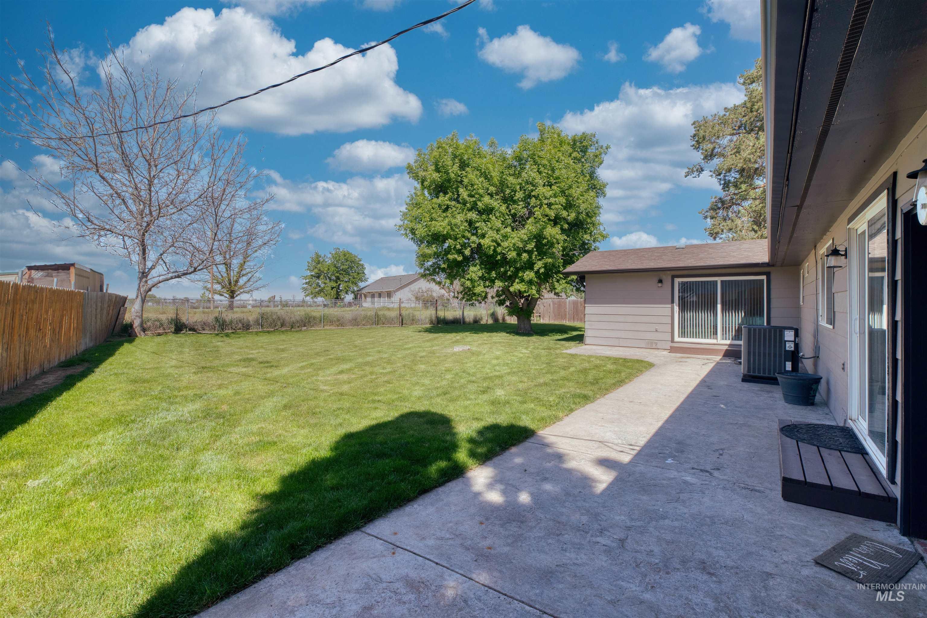 20803 Friends Road Greenleaf, ID 83626 - Photo 27 of 39 Expansive backyard featuring a lush lawn, mature trees, and a wooden perimeter fence