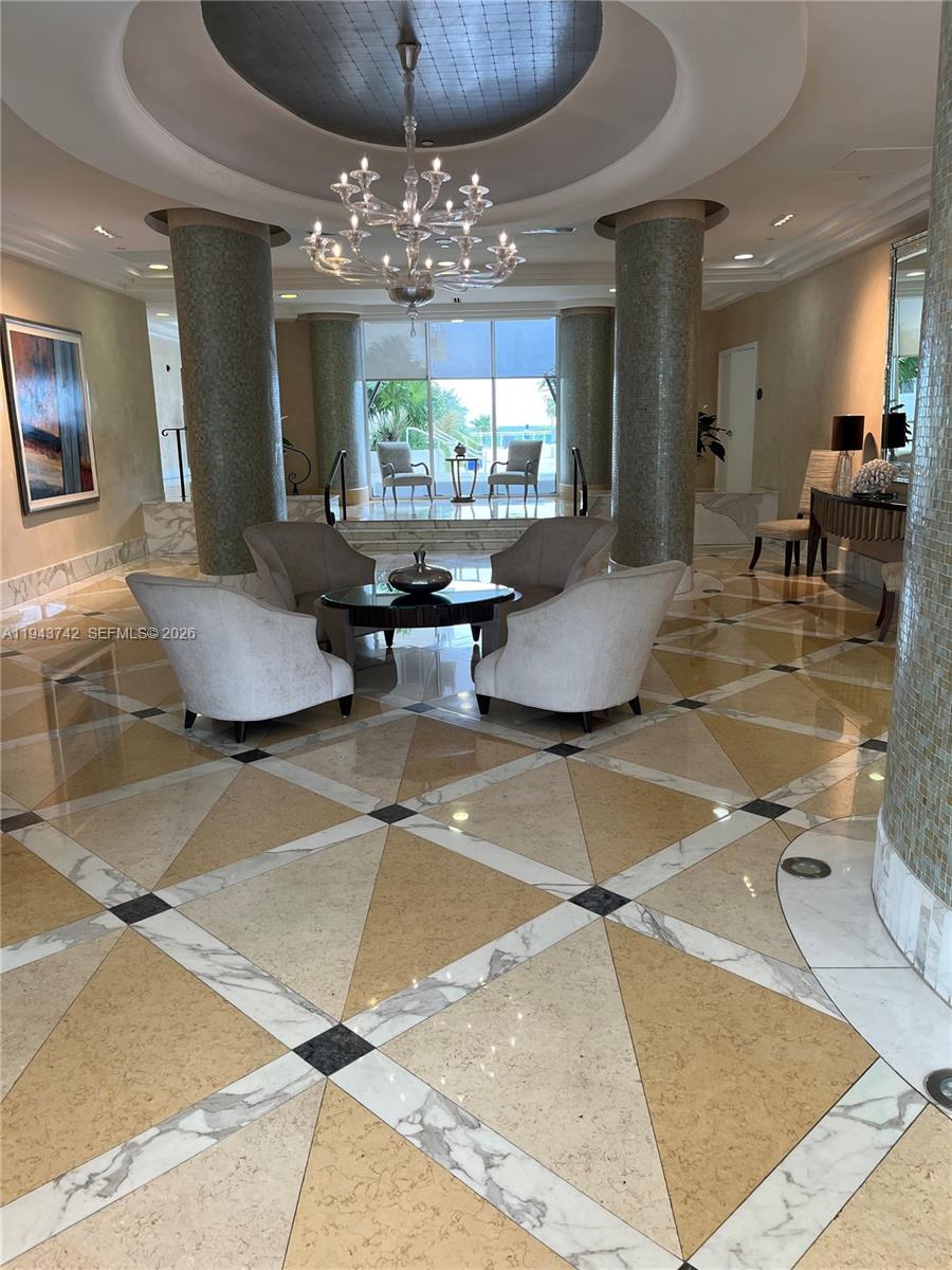 6917 Collins Avenue, Unit 426 Miami Beach, FL 33141 - Photo 11 of 15 a living room with dining table and a chandelier