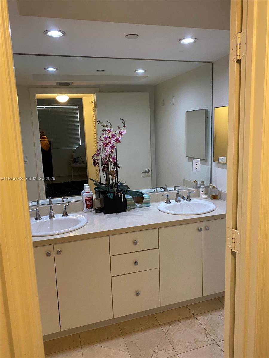 6917 Collins Avenue, Unit 426 Miami Beach, FL 33141 - Photo 6 of 15 a bathroom with a double vanity sink and a mirror