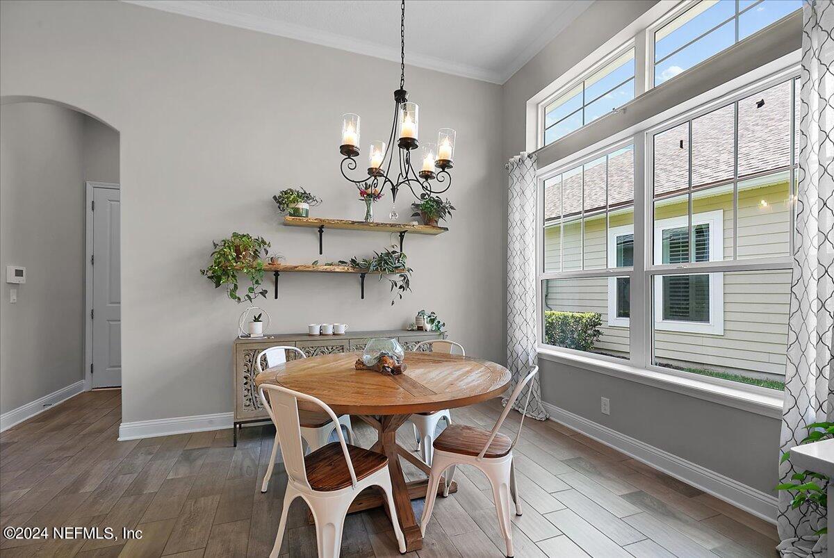 447 Glenneyre Circle St. Augustine, FL 32092 - Photo 11 of 44 a view of a dining room with furniture large windows and wooden floor