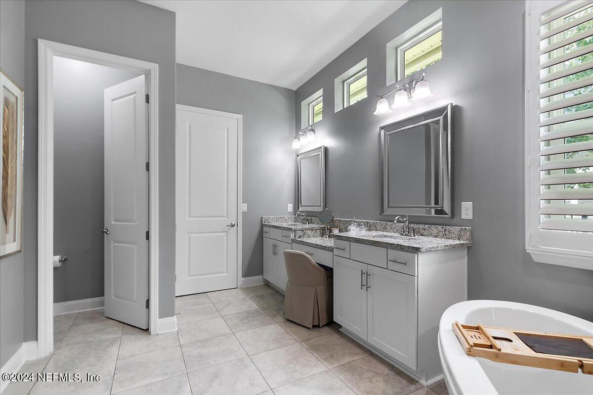 447 Glenneyre Circle St. Augustine, FL 32092 - Photo 16 of 44 a bathroom with a granite countertop sink a toilet and a mirror