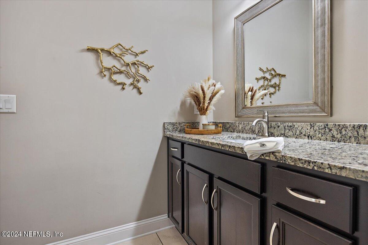 447 Glenneyre Circle St. Augustine, FL 32092 - Photo 19 of 44 a bathroom with a granite countertop sink and a mirror