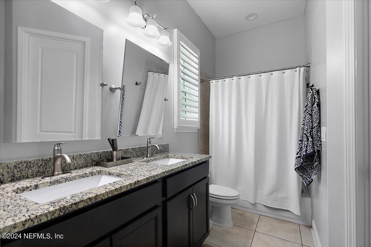 447 Glenneyre Circle St. Augustine, FL 32092 - Photo 23 of 44 a bathroom with a granite countertop sink toilet and a mirror