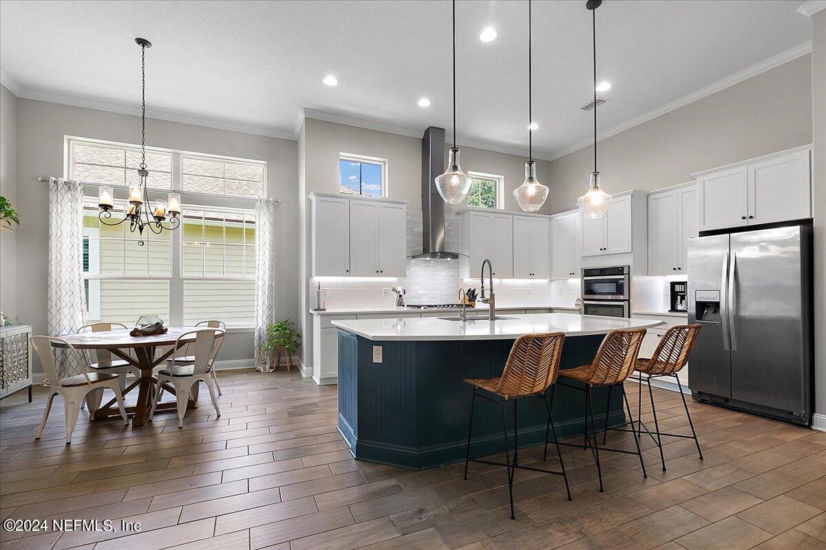 447 Glenneyre Circle St. Augustine, FL 32092 - Photo 9 of 44 a kitchen with stainless steel appliances kitchen island granite countertop a table chairs and a chandelier