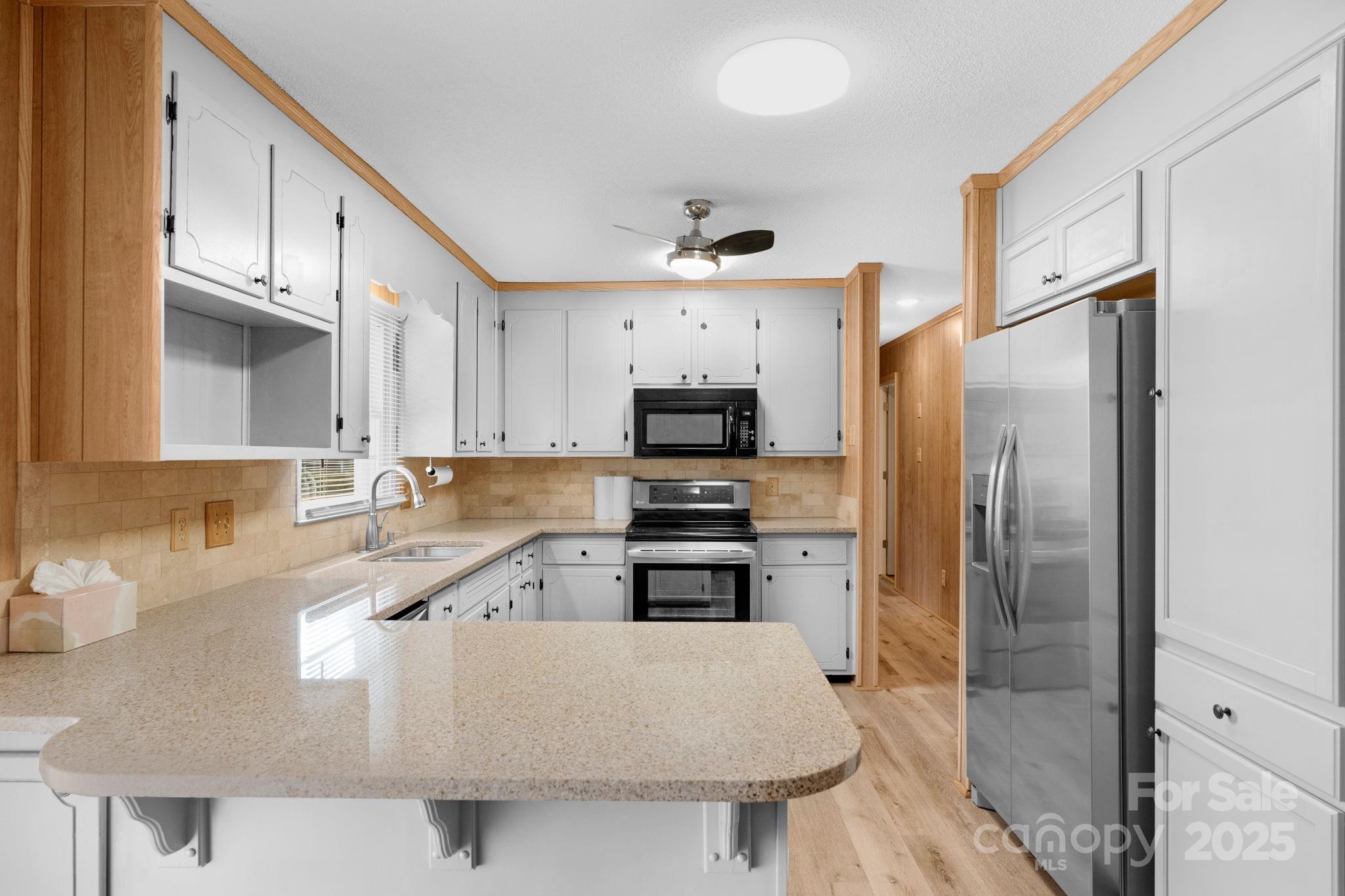 1202 Flowe Drive Matthews, NC 28104 - Photo 20 of 47 a large kitchen with stainless steel appliances granite countertop a refrigerator a stove and a sink with wooden floor