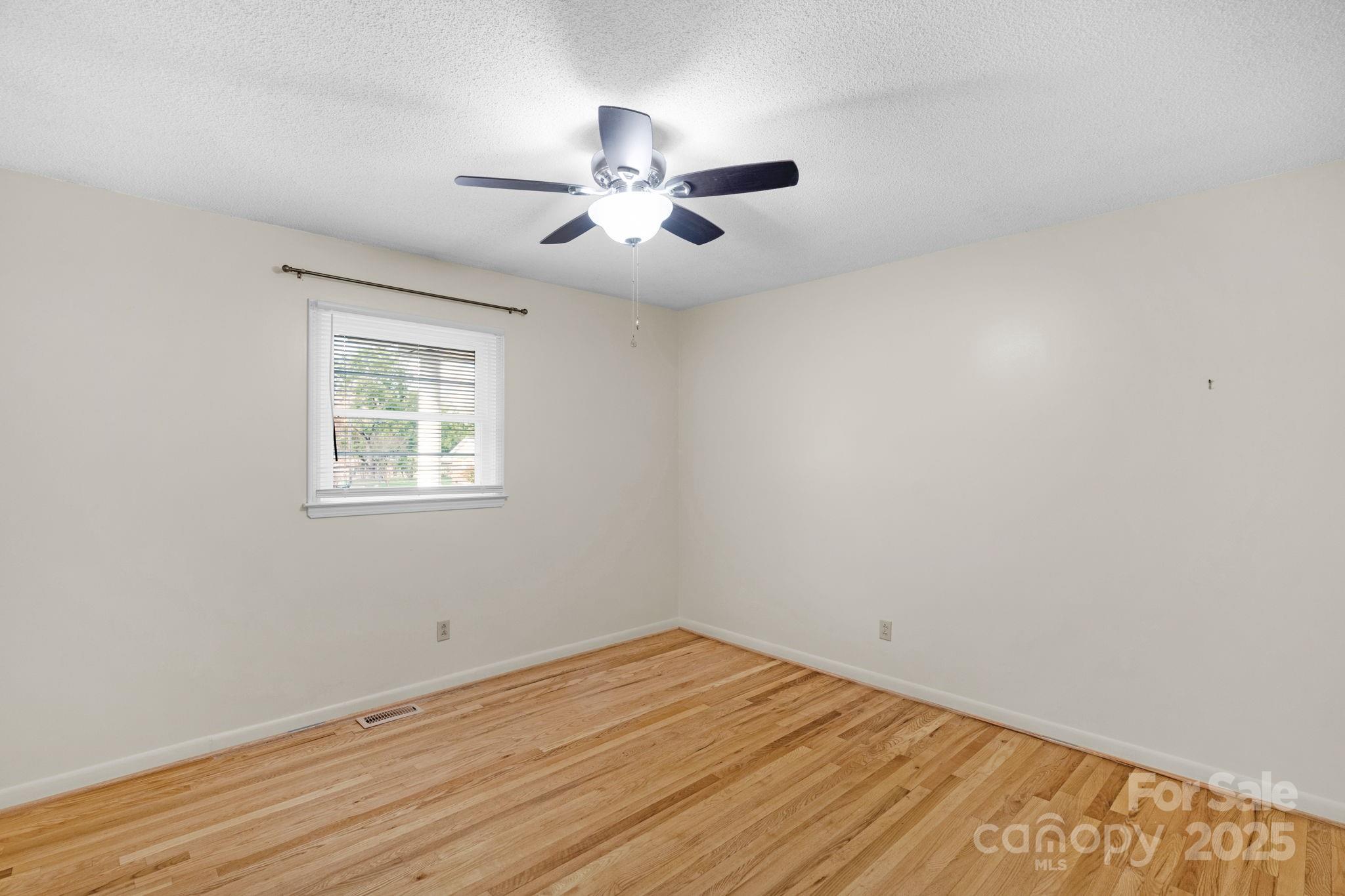 1202 Flowe Drive Matthews, NC 28104 - Photo 31 of 47 an empty room with wooden floor fan and windows