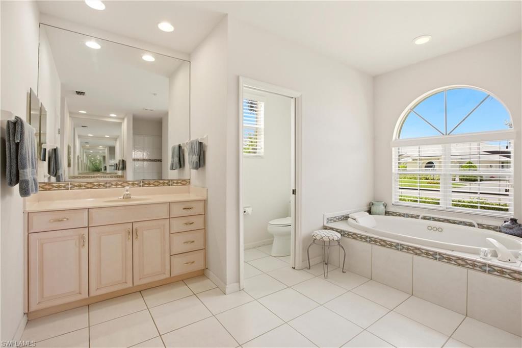 10815 Phoenix Way Naples, FL 34119 - Photo 18 of 40 a spacious bathroom with a granite countertop sink a mirror and a bathtub
