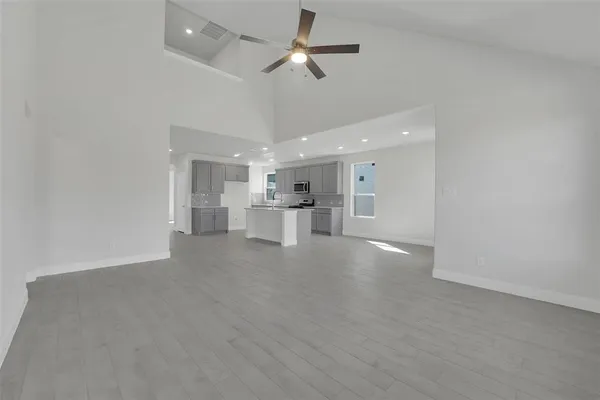 a view of an empty room and kitchen view