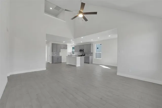 a view of an empty room and kitchen view