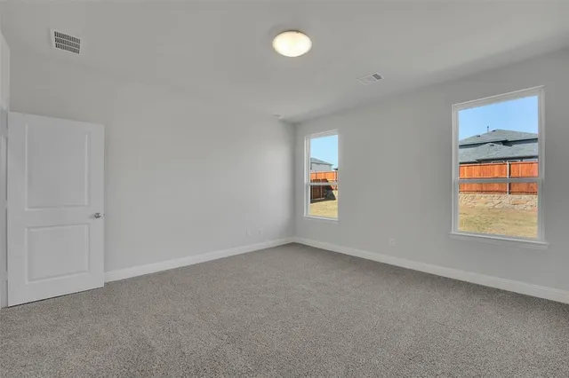 a view of an empty room with a window and closet area