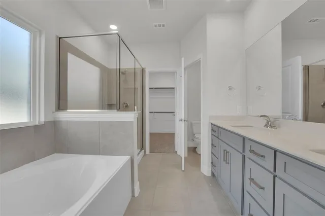 a bathroom with a tub sink and mirror