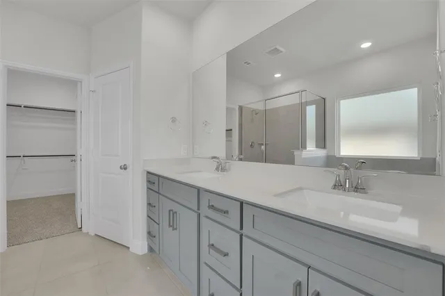 a bathroom with double vanity sink and a mirror
