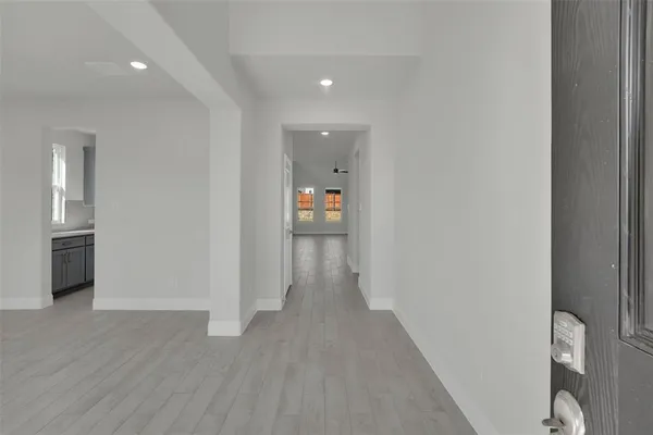 a view of a hallway with wooden floor and bathroom