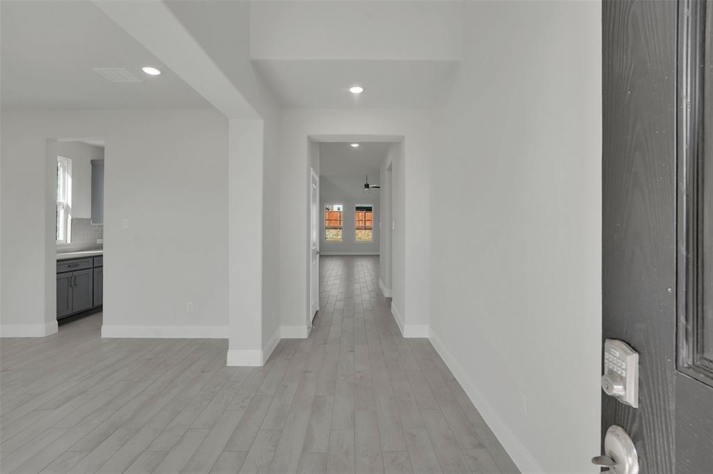 3112 Giovanni Point Princeton, TX 75407 - Photo 4 of 37 a view of a hallway with wooden floor and bathroom