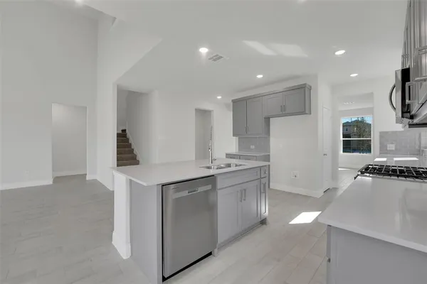 a kitchen with stainless steel appliances granite countertop a sink a stove a refrigerator and a stove