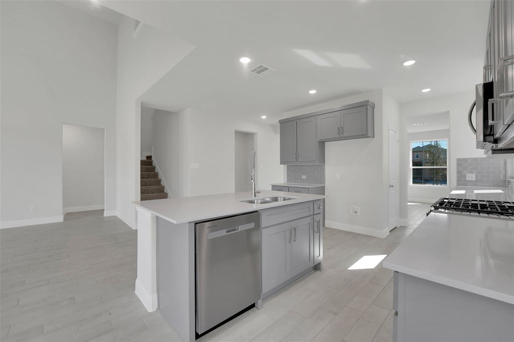 3112 Giovanni Point Princeton, TX 75407 - Photo 10 of 37 a kitchen with stainless steel appliances granite countertop a sink a stove a refrigerator and a stove