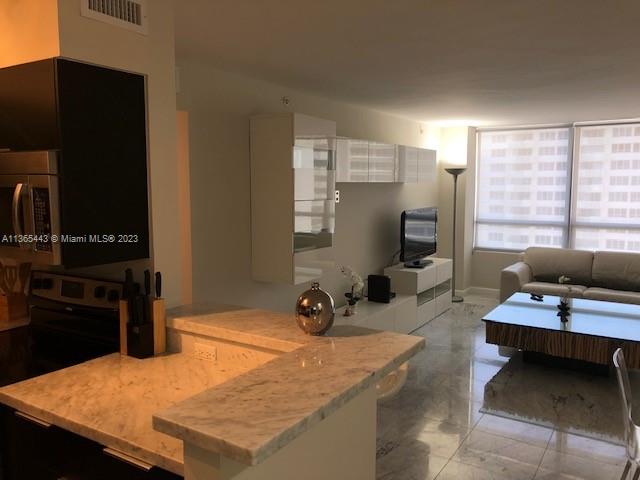 a view of a workspace with furniture and a window